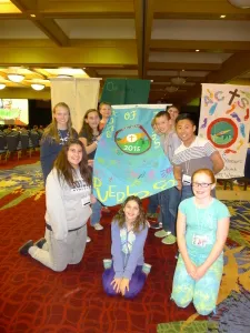 King of Kings youth holding the banner they created for the youth gathering.